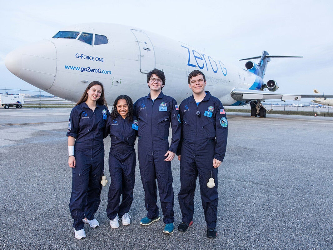 Group photo of SEES Alumni microgravity students standing in front of a ZERO-G airplane.