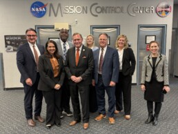 Group photo of UT System Chancellor John M. Zerwas MD with UT faculty members at NASA JSC Mission Control Center.