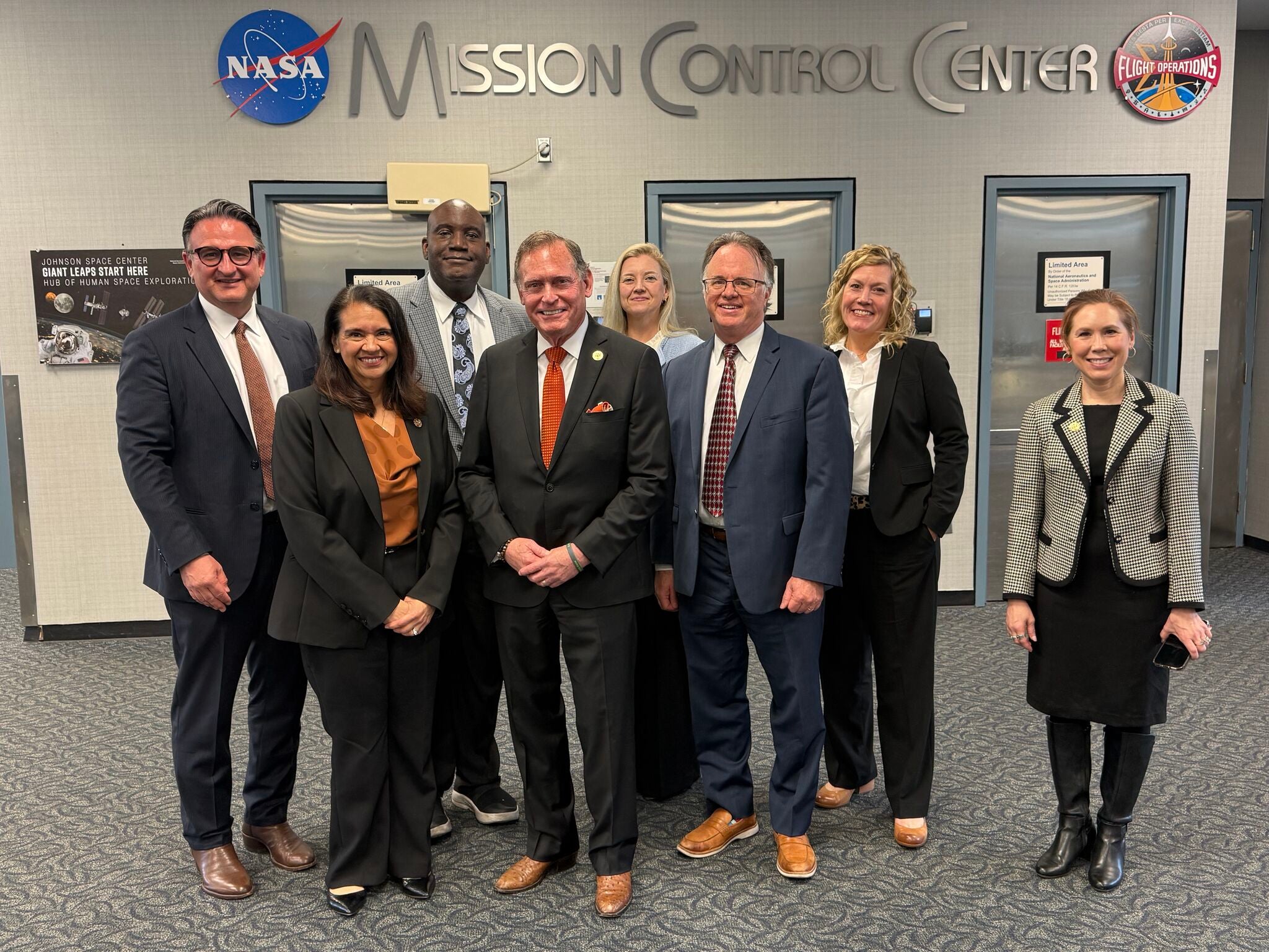 Group photo of UT System Chancellor John M. Zerwas MD with UT faculty members at NASA JSC Mission Control Center.