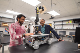 Texas Engineer Maruthi Akella and graduate student working on aerospace machinery in his lab.